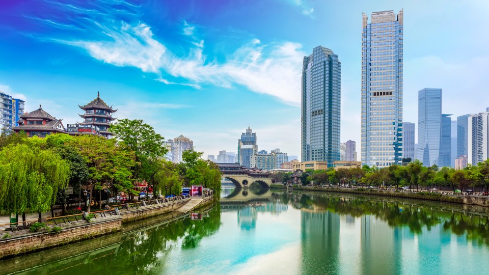 Chengdu skyline with river, modern skyscrapers, and traditional architecture in the foreground.