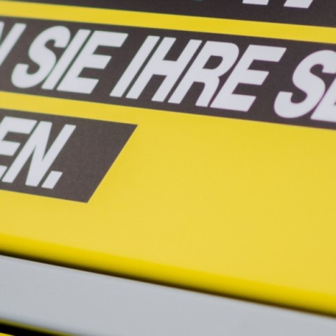 Gelbe Abholstation mit Aufschrift „Hier können Sie Ihre Sendung selbst abholen.“