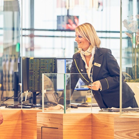 View from the airport information desk. A couple gets information from a Vienna Airport employee.