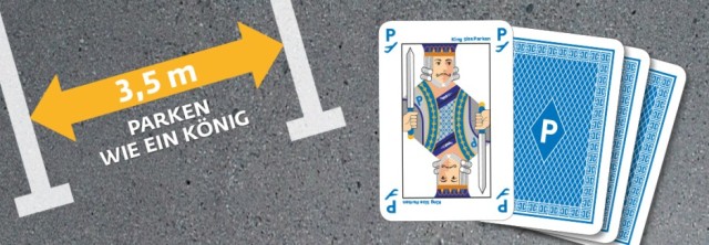Spielkarte mit König und Text „3,5 m – Parken wie ein König“ auf Asphalt mit Parkplatzmarkierung.